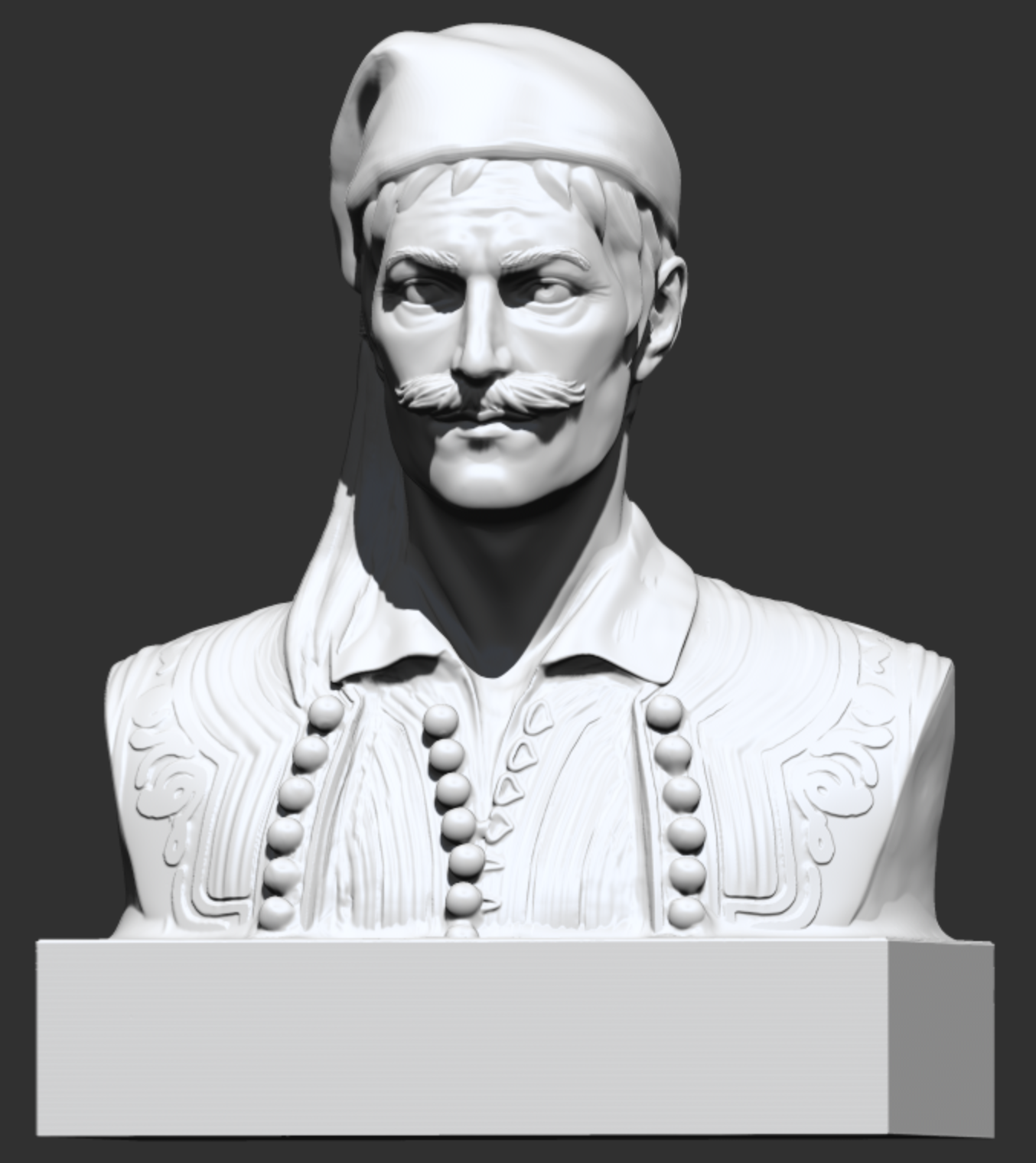 A sculpted 3D bust, seen from the front, of a moustached man in a headscarf and traditional embroidered vest on a square base.